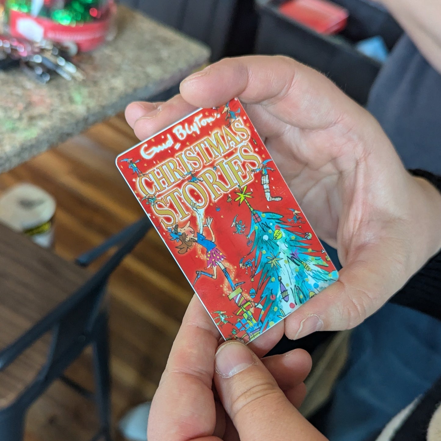 Hand holding a colorful Christmas yoto card