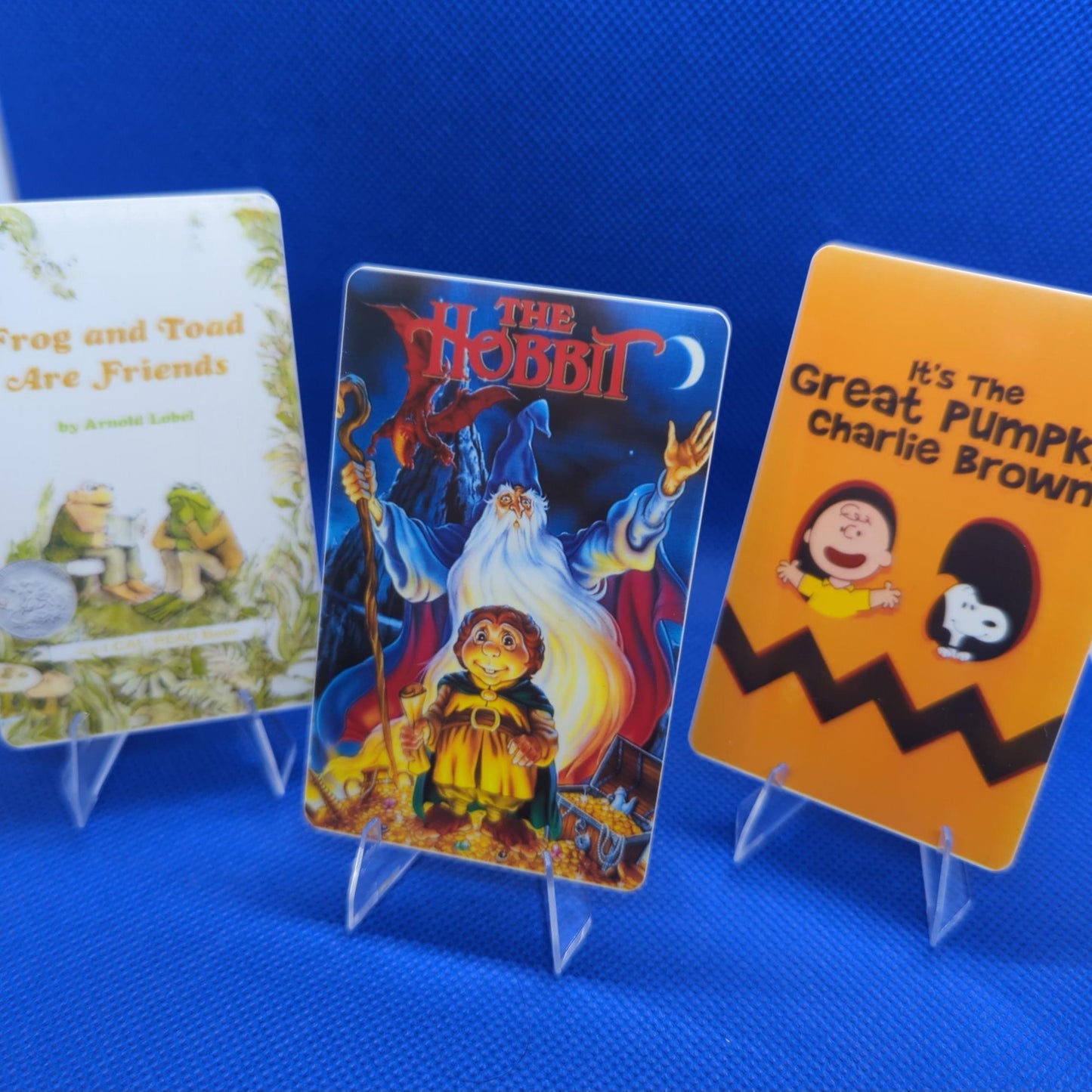 Yoto cards on stands, one with The Hobbit printed on it, the others have Frog and Toad and "It's the Great Pumpkin Charlie Brown."