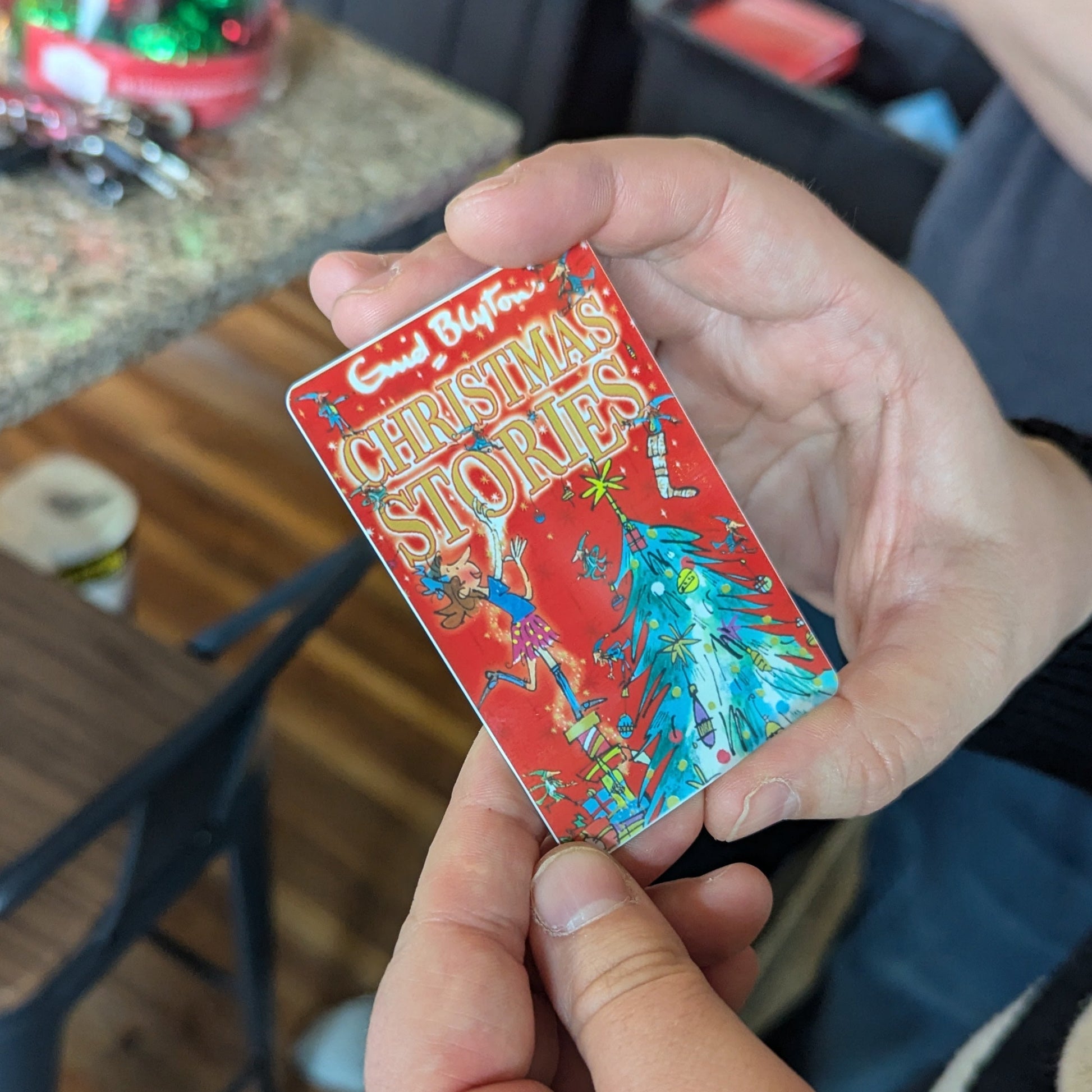 Hand holding a colorful Christmas yoto card